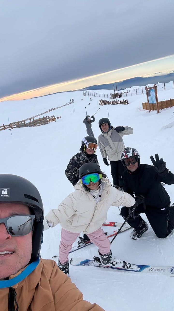 Família esquiando em Valle Nevado, nos Andes do Chile, ao pôr do sol